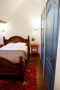 Schlafzimmer mit einem Bett mit blauer Tür und einem roten Teppich in der Unterkunft Moulin de Petoulle in Charenton sur Cher