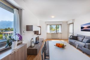 a living room with a table and a couch at Riviera Beach House in Calceranica al Lago +4 photos