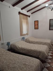 a room with two beds and a window in it at Casa Rural La Loma in Cabeza del Buey