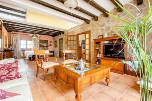 a living room with a table and a tv at Masia Castellvi in Vinyols i els Arcs