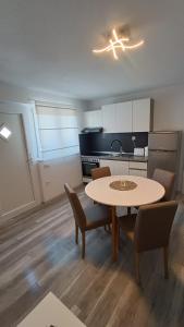een keuken met een tafel en stoelen in een kamer bij Apartments Borić in Cres
