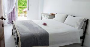 a bedroom with a white bed and a window at FBM Anagenessis - Ευ Ζην 2 in Edessa