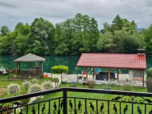 een huis met een tuinhuisje en een meer bij Aventurin Superior Apartments in Bihać