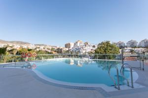 een groot zwembad met een stad op de achtergrond bij 2 bedroom Luxury apartment in Benalmádena in Benalmádena