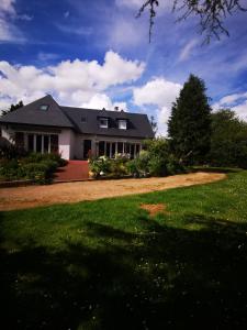 une maison avec une grande cour avec une pelouse verte dans l'établissement Catherine et Serge, à Genêts