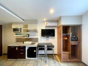 eine kleine Küche mit einem Tisch und 2 Hockern in der Unterkunft Arawana Express Phromphong in Bangkok