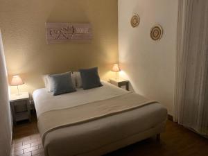 ラントンにあるLOGIS HOTELS - Hôtel et Restaurant L'Océanaのベッドルーム1室(大型ベッド1台、テーブル2台、ランプ2つ付)