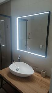 een badkamer met een witte wastafel en een spiegel bij Apartments Borić in Cres