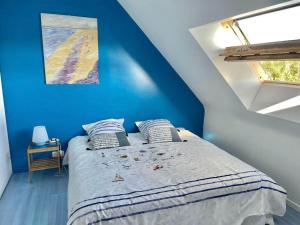 Schlafzimmer mit einem Bett mit blauer Wand in der Unterkunft La Villa KEROMER in Étel