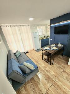 ein Wohnzimmer mit einem Sofa und einem Tisch in der Unterkunft Piçarras - 400 metros da praia in Piçarras