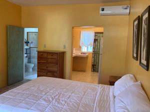 a bedroom with a large bed and a bathroom at Su Casa Bonita, Negril in Negril