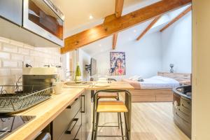 a kitchen with a counter and a bed in a room at NEW / Belle et Rebelle avec jacuzzi in Lyon