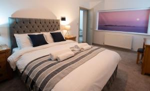 um quarto com uma cama grande e toalhas em Modern Buxton Town House em Buxton
