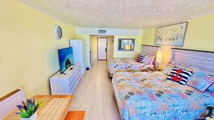 um quarto de hotel com duas camas e uma televisão em Ocean Reef- Unique Oceanfront Condo-Free parking - Amazing pools em Myrtle Beach