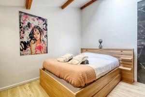 a bedroom with a bed and a painting on the wall at NEW / Belle et Rebelle avec jacuzzi in Lyon