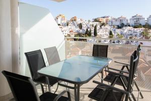 een tafel en stoelen op een balkon met uitzicht bij 2 bedroom Luxury apartment in Benalmádena in Benalmádena