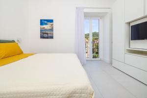 圣安吉洛Tordara House - Elegant apt的一间带床和电视的白色卧室