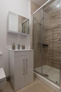 a bathroom with a shower and a toilet and a sink at Modern Buxton Town House in Buxton