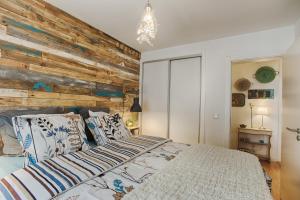 a bedroom with a wooden accent wall and a bed at BmyGuest - 28 Tram Central Apartment in Lisbon