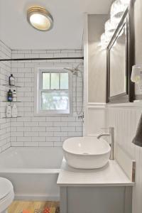 a white bathroom with a sink and a tub at Bohemian Bungalow Pac-Man, walk downtown, pet friendly in Columbia