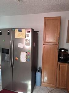 a kitchen with a stainless steel refrigerator and a wooden cabinet at Cozy 2BR/1BA retreat in St.Kitts close to airport in Romneys