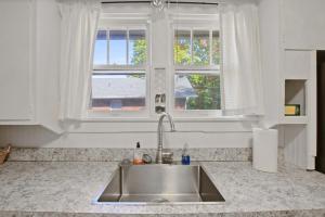 a kitchen with a sink and two windows at Bohemian Bungalow Pac-Man, walk downtown, pet friendly in Columbia +48 photos