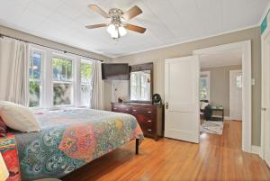 a bedroom with a bed and a ceiling fan at Bohemian Bungalow Pac-Man, walk downtown, pet friendly in Columbia