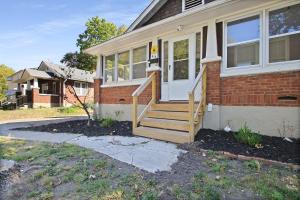 a brick house with a white door and stairs at Bohemian Bungalow Pac-Man, walk downtown, pet friendly in Columbia