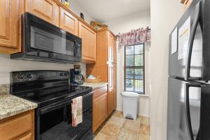 a kitchen with a black stove and a microwave at Ozark Comfort Condo in Branson West