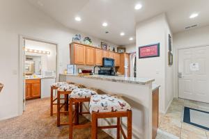 a kitchen with two stools at a bar with a counter top at Ozark Comfort Condo in Branson West