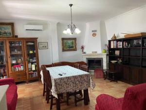 a dining room with a table and a fireplace at A casa da Maria in Luz de Tavira