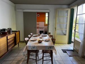a dining room with a table and chairs and a kitchen at Chalet au bord de l'étang 4 pers in Les Boulmiers