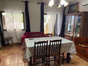 a dining room with a table and a couch at A casa da Maria in Luz de Tavira