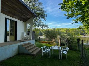 a table and chairs on the side of a house at Chalet au bord de l'étang 4 pers in Les Boulmiers
