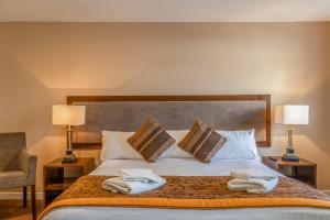 1 dormitorio con 1 cama con toallas en Muthu Newton Hotel (Near Inverness Airport) en Nairn
