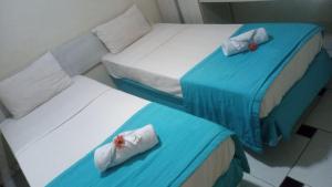 two beds in a room with blue and white at Hotel Arrecife dos Corais in Cabo de Santo Agostinho