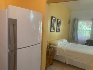 a bedroom with a white refrigerator and a bed at Su Casa Bonita, Negril in Negril