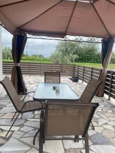 einen Tisch und Stühle unter einem Sonnenschirm auf einer Terrasse in der Unterkunft THOMAS STUDIOS & APARTMENTS PARALIA in Paralia Katerinis