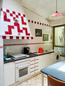 una cucina con parete a scacchi rossa e bianca di 2 bedrooms apartement with enclosed garden at Vita a Vita