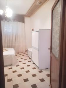 a room with a white refrigerator and a bed at 2 bedrooms apartement with enclosed garden at Vita in Vita