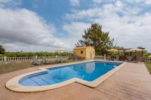 a swimming pool with a wooden deck next to a house at Masia Castellvi in Vinyols i els Arcs