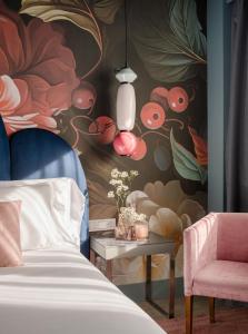 a bedroom with a bed and a floral wall at Hotel Antik San Sebastián in Donostia-San Sebastián