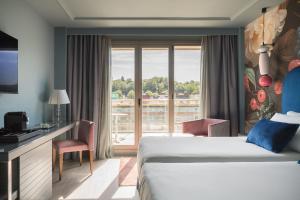 una camera d'albergo con un letto e una grande finestra di Hotel Antik San Sebastián a San Sebastián