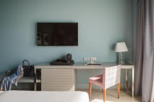 einen Schreibtisch mit einem TV an einer blauen Wand in der Unterkunft Hotel Antik San Sebastián in San Sebastián