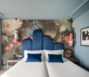 a bedroom with a large bed with a floral wall at Hotel Antik San Sebastián in Donostia-San Sebastián