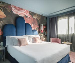 a bedroom with a large bed with a floral wall at Hotel Antik San Sebastián in Donostia-San Sebastián