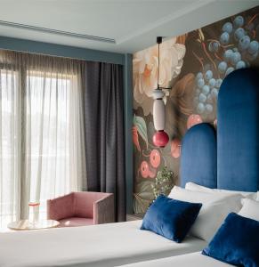 a bedroom with a bed and a wall with a painting at Hotel Antik San Sebastián in Donostia-San Sebastián