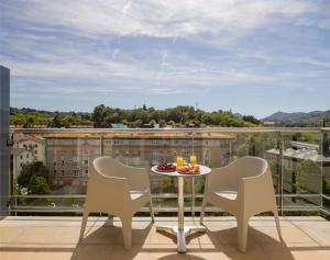 a table and chairs on a balcony with a view at Hotel Antik San Sebastián in Donostia-San Sebastián