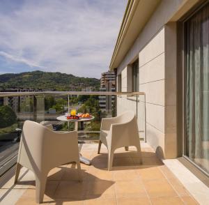 a balcony with two chairs and a table at Hotel Antik San Sebastián in Donostia-San Sebastián