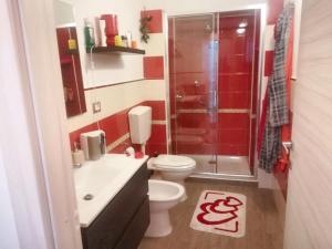 a red bathroom with a toilet and a shower at 2 bedrooms apartement with sea view furnished terrace and wifi at Pianoconte 2 km away from the beach in Piano Conte